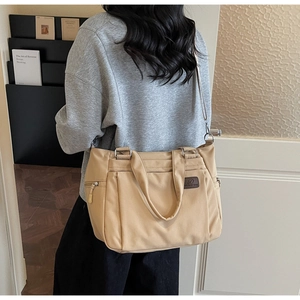 Vue détaillée du sac cabas en nylon kaki avec plusieurs poches et bandoulière réglable