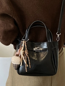 Minimalist black shiny leather bucket bag with silver turn-lock and creative charms