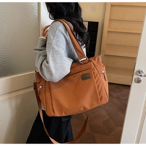 Vue détaillée du sac cabas caramel montrant le tissu imperméable et les fermetures éclair