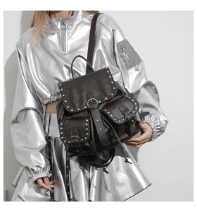 Vue détaillée d'un sac à dos rétro marron foncé avec rivets argentés et boucles métalliques