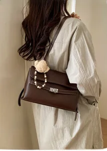 Detail of vintage brown leather crossbody bag with white stitching and silver twist lock