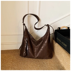 Détail du grand sac hobo marron foncé avec texture en cuir huilé et rivets argentés