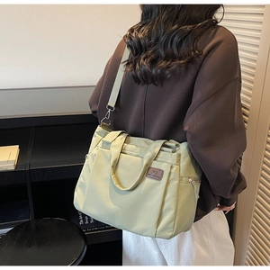 Gros plan sur un sac cabas en nylon vert avec fermetures éclair argentées et texture lisse