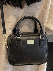 Classic black leather Boston handbag with gold hardware and adjustable crossbody strap
