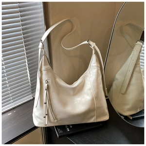 Détail du sac Hobo crème avec une fermeture éclair verticale et une large bandoulière
