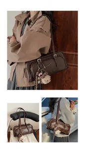 Detail view of vintage dark brown bowling bag featuring plush bear charm and strap accents