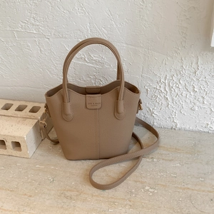 Detail der khakifarbenen Beuteltasche mit litschi-textur leder und goldener hardware