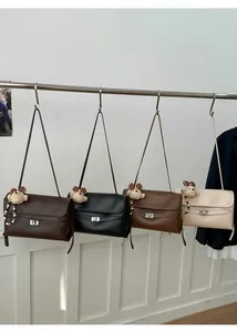 Detailed view of leather shoulder bags in four colors with cute teddy bear pendants