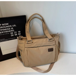 Détail du sac cabas en nylon kaki avec bandoulière réglable et ferrures métalliques solides