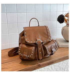 Vue détaillée du sac à dos vintage marron avec rivets argentés et boucles en cuir