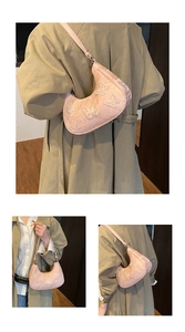 Detail view of a pale pink crescent shoulder bag with white butterfly lace embroidery