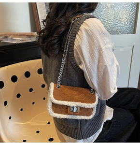 Back view of model wearing brown suede crossbody bag with white plush trim and chain strap