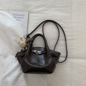 Macro shot of dark brown wax leather texture and silver buckle on chic bucket bag
