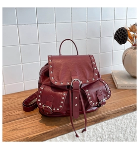 Gros plan du sac à dos vintage bordeaux avec rivets argentés et texture cuir grainé