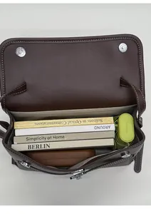Spacious interior of brown vintage messenger bag showing capacity for books and umbrella