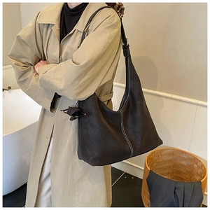Détail du sac cabas en cuir mat marron foncé avec coutures contrastées blanches