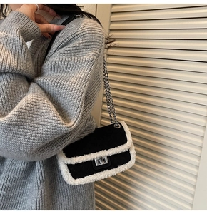 Detail of a chic quilted black crossbody bag with white fleece trim and silver chain