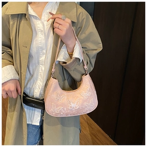 Detailed close-up of pink butterfly lace embroidery and texture on the half-moon hobo bag