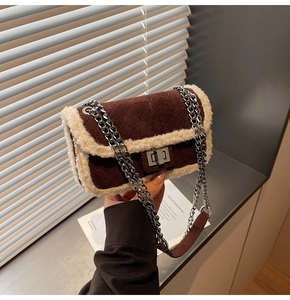 Detail of brown suede quilted handbag with white faux fur trim and silver metal chain strap