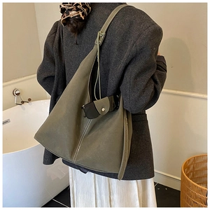 Grand sac cabas en daim vert olive avec coutures contrastées blanches porté par un mannequin