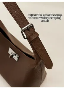 Detail view of brown lychee leather shoulder bag with adjustable strap and silver buckle