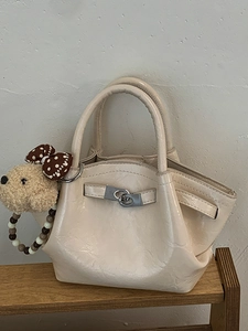 Minimalist cream white structured tote bag with glossy leather and plush dog charm