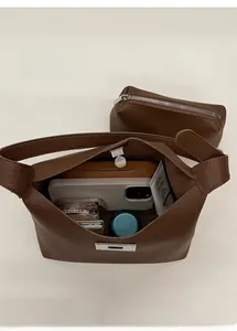 Top-down view of a brown pebbled leather bucket bag with spacious interior and matching pouch