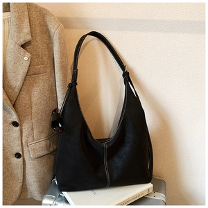 Détail du sac hobo noir avec des coutures contrastées blanches et une finition mate chic