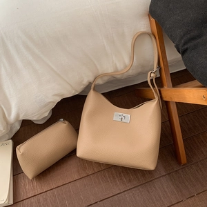 Detail of beige lychee leather underarm bag and matching zipper pouch with silver lock
