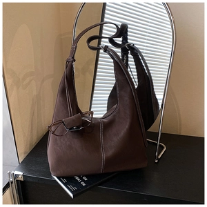 Détail du sac porté épaule marron foncé avec coutures contrastées et nœuds décoratifs