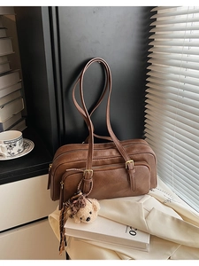 Detailed macro of vintage brown leather bowling bag featuring textures and plush charm