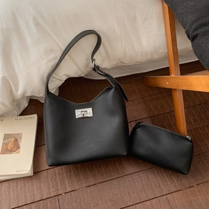 Detail of black litchi grain leather shoulder bag with silver twist lock and pouch