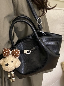 Minimalist black pleated leather tote bag with a cute teddy bear charm and silver hardware