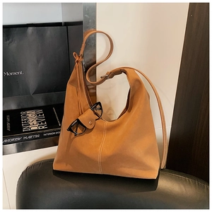 Détail d'un sac Hobo marron avec surpiqûres blanches et bandoulière réglable en cuir
