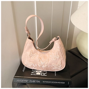 Close-up of pink lace shoulder bag featuring delicate white butterfly appliques and silver hardware
