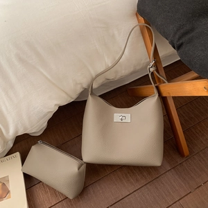 Detail of lychee pattern leather shoulder bag with matching zipper pouch and metal lock
