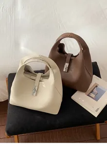 Detailed view of two vintage bucket bags featuring textured leather and metal turn-lock clasp