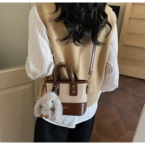 Détail du sac seau en toile avec breloque lapin en peluche porté sur le dos