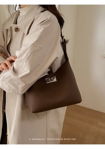 Detail of silver twist lock on dark brown pebble leather hobo bag with retro minimalist aesthetic