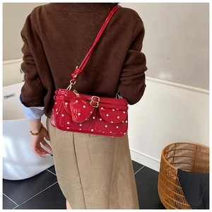 Rückansicht eines Models mit roter Polka-Dot-Mini-Umhängetasche und Herz-Anhänger