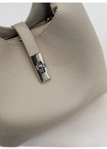 Detail of premium lychee texture leather and silver metal twist lock on bucket bag