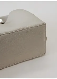 Detail of lychee pattern leather bucket bag base showing reinforced stitching and structure