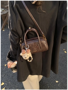 Détail du sac bowling vintage marron foncé avec un joli pendentif ours en peluche