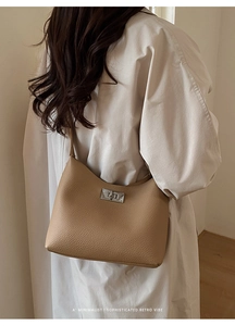 Detail view of khaki pebbled leather shoulder bag with silver metal twist lock buckle