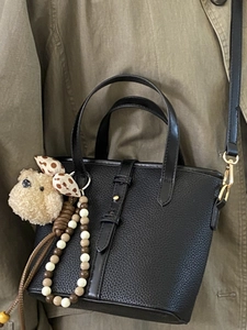 Minimalist black lychee pattern bucket bag with cute bear charm and golden hardware detail