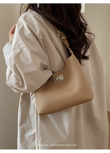 Close-up of khaki hobo bag with silver turn-lock and premium lychee pattern leather