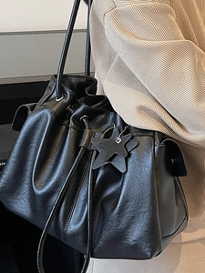 Large black drawstring tote bag in textured faux leather with star charm for women