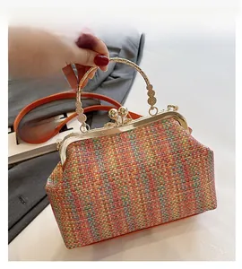 Détail du sac tissé coloré avec cadre en métal doré et poignée avec motifs en relief