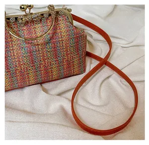 Détail du sac tressé multicolore avec fermoir nœud en cristal et bandoulière orange