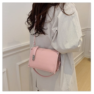 Pink lychee grain leather crossbody bag detail with silver hardware and shoulder strap